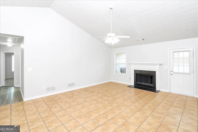 unfurnished living room featuring ceiling fan, light tile patterned floors, vaulted ceiling, and a healthy amount of sunlight