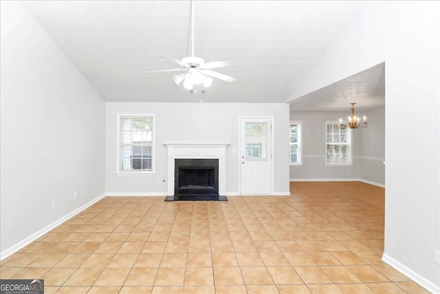 unfurnished living room featuring ceiling fan with notable chandelier, lofted ceiling, plenty of natural light, and light tile patterned flooring