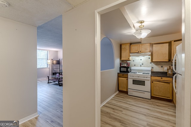 kitchen featuring tasteful backsplash, a textured ceiling, light hardwood / wood-style floors, and white appliances