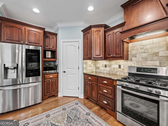 kitchen with light hardwood / wood-style floors, crown molding, custom exhaust hood, and stainless steel gas range