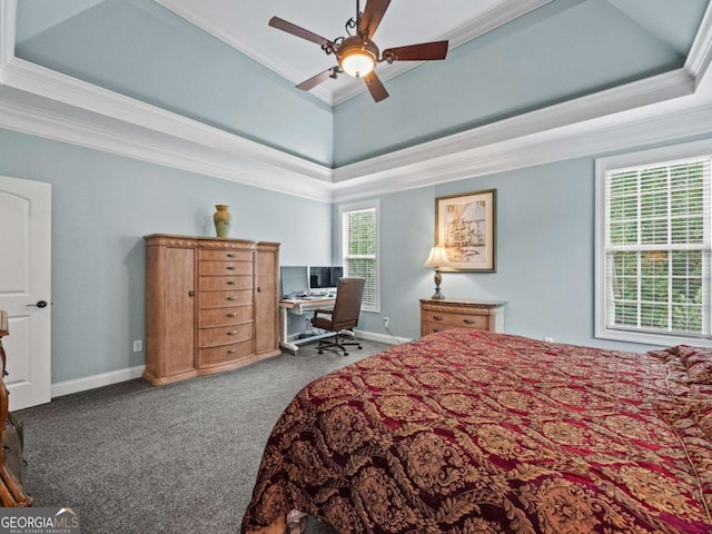 bedroom featuring carpet flooring, ensuite bath, ornamental molding, a tray ceiling, and ceiling fan