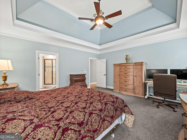 carpeted bedroom featuring a tray ceiling, ensuite bath, ceiling fan, and ornamental molding