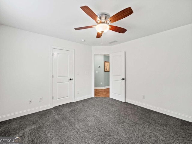 unfurnished room featuring dark colored carpet and ceiling fan