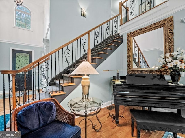 living room with ornamental molding, light hardwood / wood-style flooring, plenty of natural light, and a stone fireplace