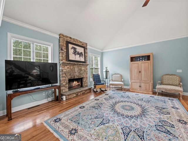 living room featuring ornamental molding, high vaulted ceiling, light hardwood / wood-style flooring, a notable chandelier, and a fireplace