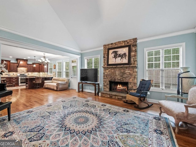 living room featuring a chandelier, crown molding, a healthy amount of sunlight, and hardwood / wood-style flooring