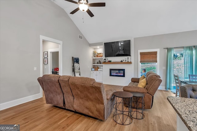 living room featuring ceiling fan, light hardwood / wood-style flooring, and high vaulted ceiling