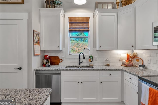 kitchen with white cabinets, appliances with stainless steel finishes, tasteful backsplash, and sink