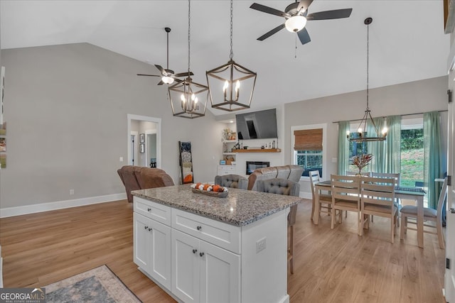 kitchen featuring light hardwood / wood-style flooring, white cabinets, and decorative light fixtures