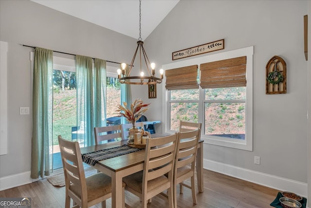 dining area with an inviting chandelier, lofted ceiling, and hardwood / wood-style floors