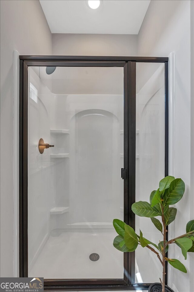 bathroom featuring a shower with door