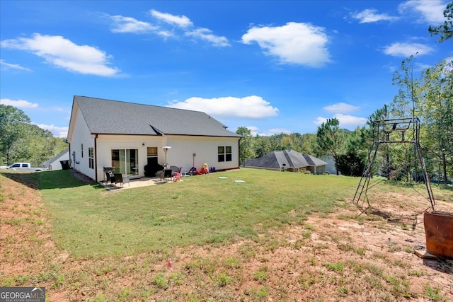 rear view of house with a lawn and a patio