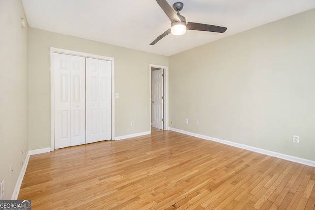 unfurnished bedroom featuring ceiling fan, light wood-type flooring, and a closet