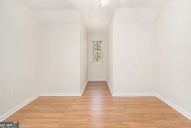 unfurnished room with light hardwood / wood-style floors and vaulted ceiling