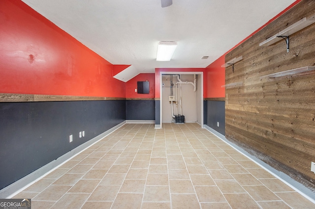 basement featuring wood walls and light tile patterned floors