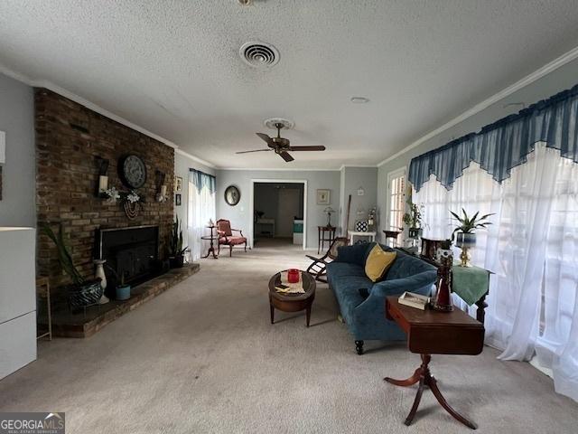 carpeted living room with crown molding, a fireplace, ceiling fan, and a textured ceiling