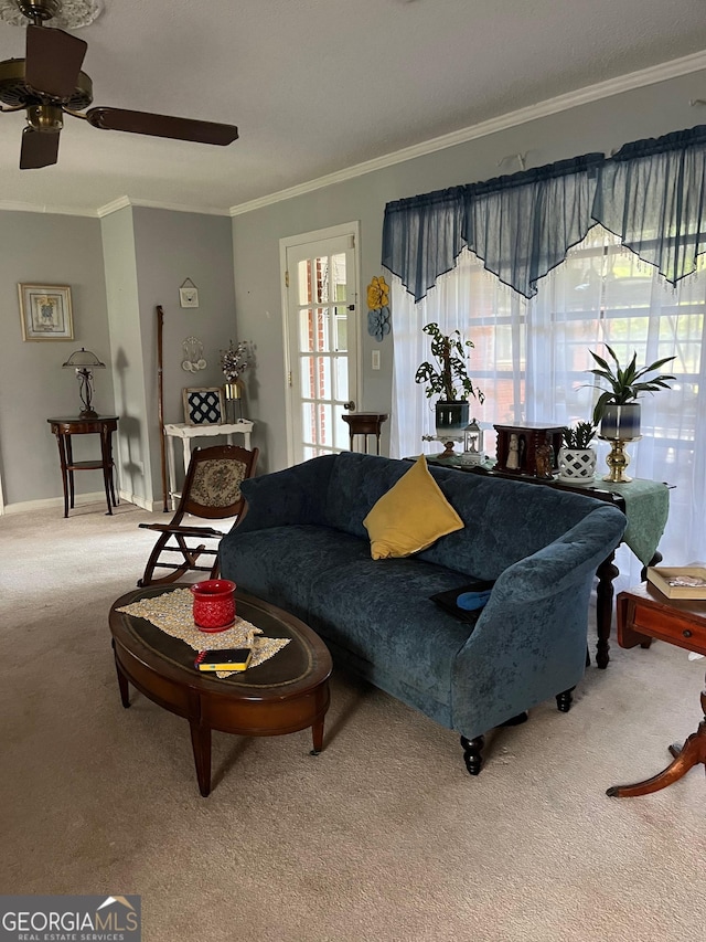 living room featuring carpet, ceiling fan, a healthy amount of sunlight, and crown molding