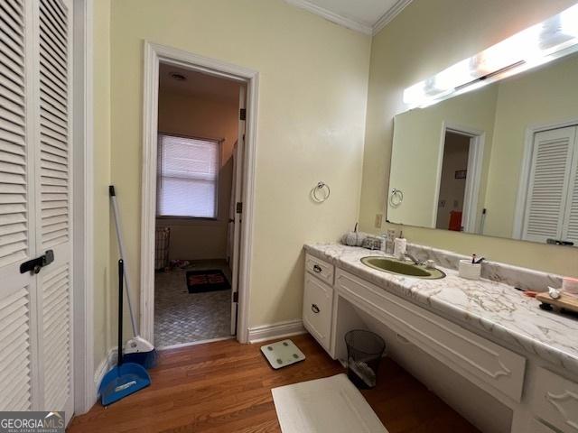 bathroom with crown molding, hardwood / wood-style floors, and vanity