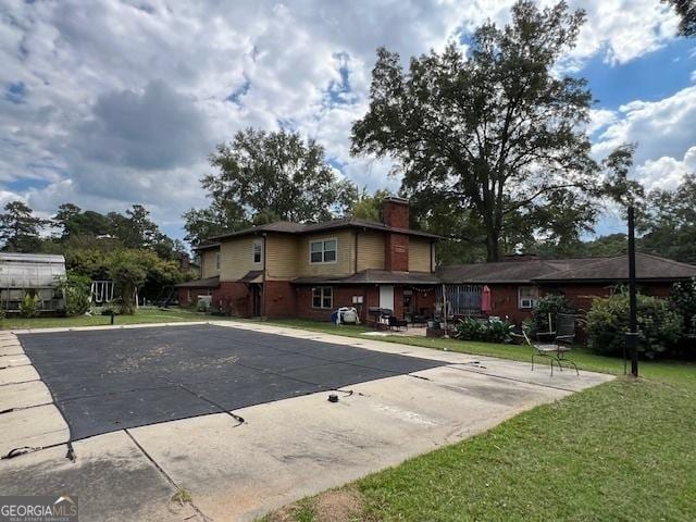 rear view of property featuring a yard