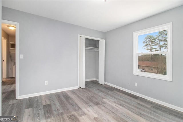 unfurnished bedroom featuring hardwood / wood-style flooring and a closet