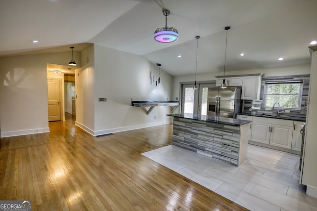 kitchen with lofted ceiling, stainless steel fridge, and light hardwood / wood-style floors