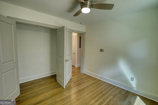 unfurnished bedroom with ceiling fan, light wood-type flooring, and a closet