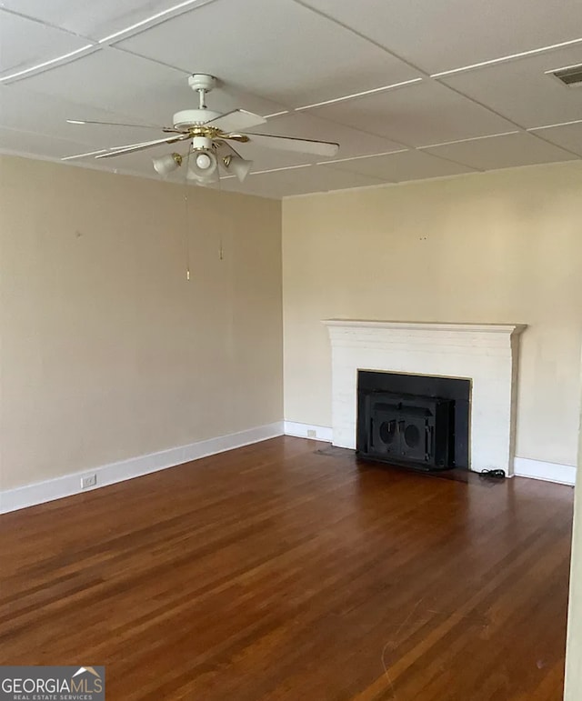 unfurnished living room with a drop ceiling, ceiling fan, and dark wood-type flooring