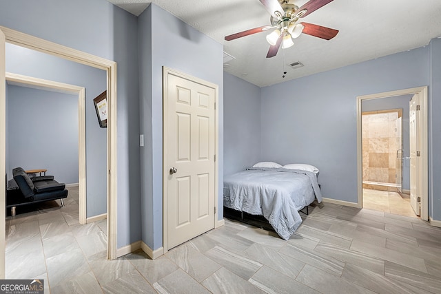 bedroom featuring ensuite bath, ceiling fan, and a textured ceiling