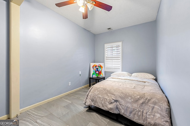 bedroom with lofted ceiling, a textured ceiling, and ceiling fan