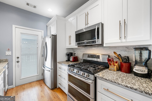 kitchen with light stone countertops, stainless steel appliances, light wood-type flooring, and white cabinetry