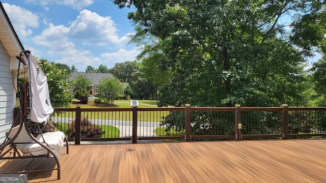 wooden terrace featuring a lawn