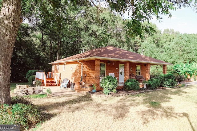 ranch-style home with covered porch and a front yard