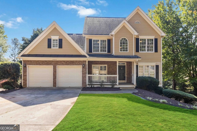 view of front of house with a front yard, a garage, and a porch