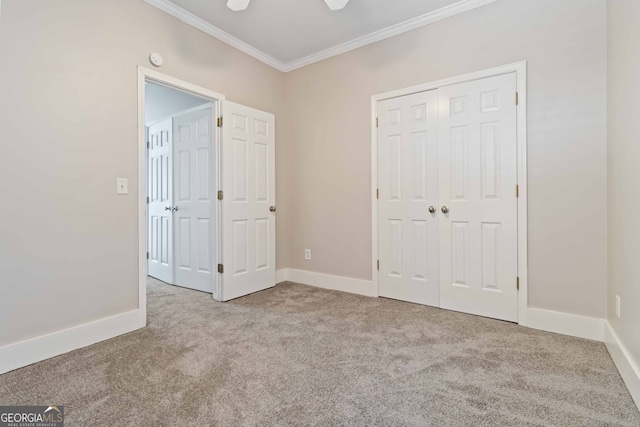 unfurnished bedroom featuring a closet, crown molding, light colored carpet, and ceiling fan