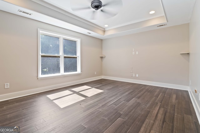 spare room featuring ceiling fan, a raised ceiling, and dark hardwood / wood-style floors