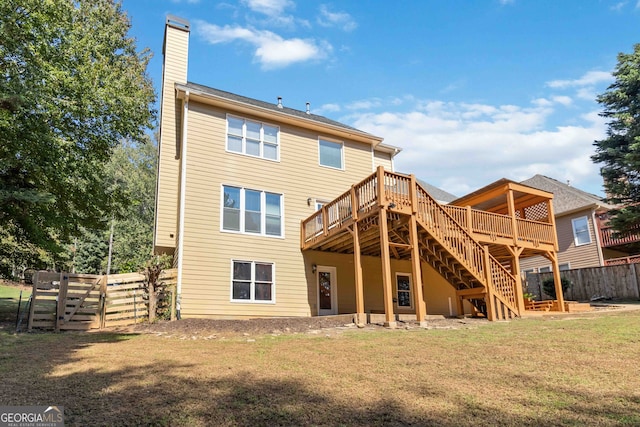 back of property featuring a lawn and a deck