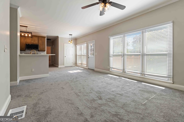 unfurnished living room with light carpet, ornamental molding, and ceiling fan