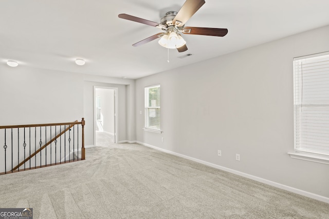 carpeted spare room featuring ceiling fan