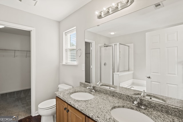 bathroom with vanity, a shower with shower door, and toilet