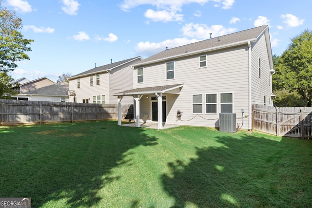 rear view of property featuring a lawn, a patio area, and central AC