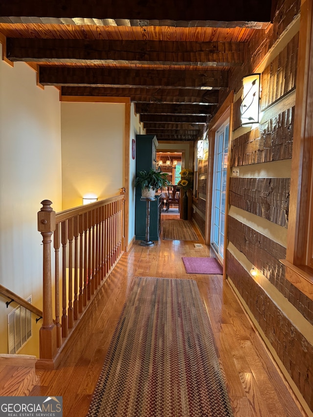 corridor with wood-type flooring, beamed ceiling, and wooden ceiling