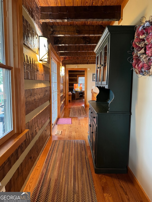 hall with french doors, beam ceiling, hardwood / wood-style floors, and wooden ceiling