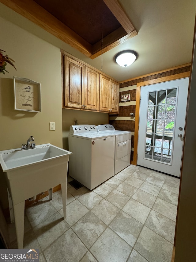 clothes washing area with cabinets and washing machine and dryer