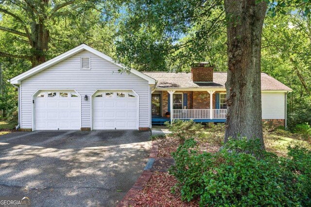 ranch-style home with a garage and covered porch