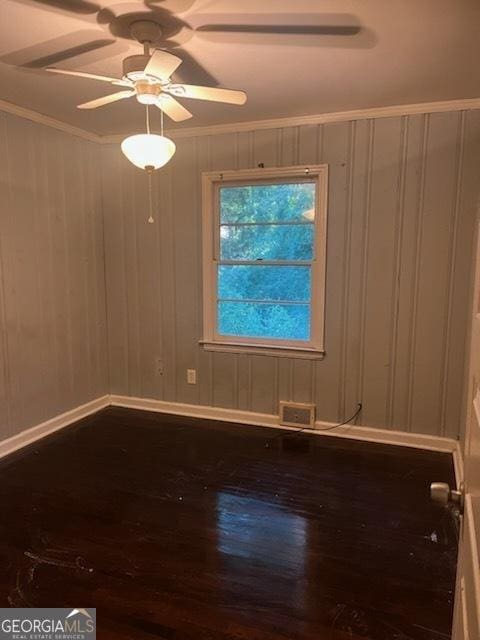 spare room featuring wood-type flooring and ornamental molding