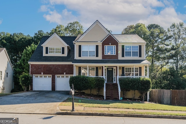 view of front of home featuring a front lawn, a porch, and a garage