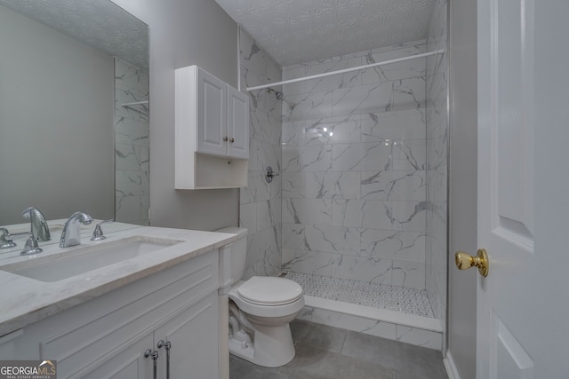 bathroom featuring a tile shower, tile patterned flooring, a textured ceiling, vanity, and toilet