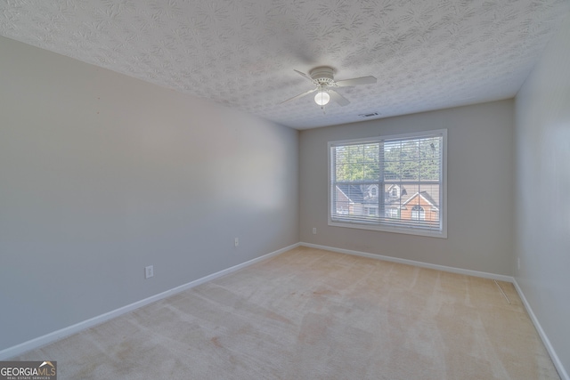 carpeted empty room featuring ceiling fan and a textured ceiling