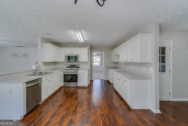 kitchen featuring a textured ceiling, dark wood-type flooring, sink, white cabinetry, and appliances with stainless steel finishes