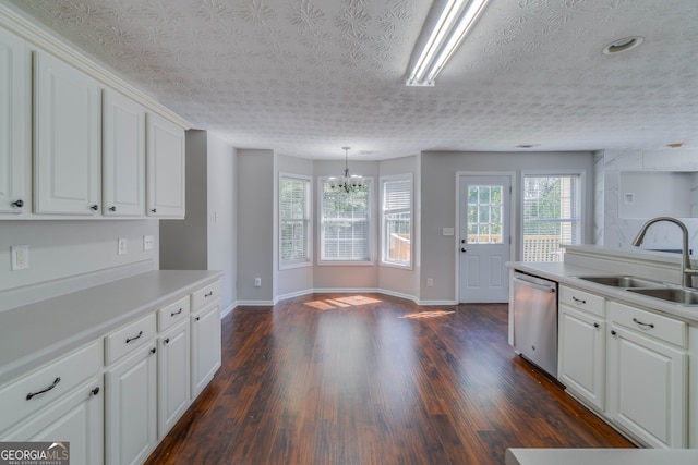 kitchen with pendant lighting, sink, stainless steel dishwasher, dark wood-type flooring, and white cabinetry